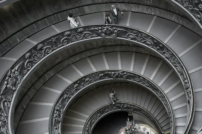 personas subiendo una escalera en espiral